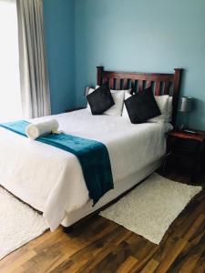 a bedroom with a large white bed with blue walls at Buxton lodge Guesthouse in Queenstown