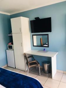 een bureau in een kamer met een bed en een computer bij Buxton lodge Guesthouse in Queenstown