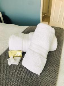 een stapel witte handdoeken op een bed bij Buxton lodge Guesthouse in Queenstown
