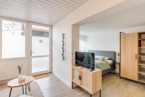 een slaapkamer met een bed en een tv op een kast bij Bijou Sternen - Bergluft und Seeträume in Faulensee