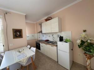 a small kitchen with a table and a white refrigerator at Sunset Sea View - Beachfront Balcony - AC - Wifi in Durrës