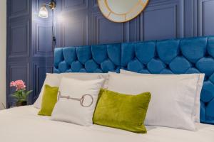 1 cama con almohadas blancas y cabecero azul en Regency Basement Apartment en Cheltenham