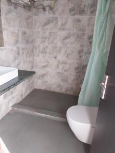 Jim Corbett Tiger Resort في Belparāo: حمام مع مرحاض ومغسلة