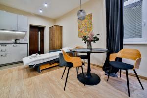 Schlafzimmer mit einem Bett, einem Tisch und Stühlen in der Unterkunft Studio ArtDeco in Rabka-Zdrój