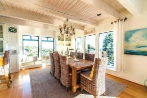 Summer Beach House في سمرلاند: غرفة طعام مع طاولة وكراسي خشبية