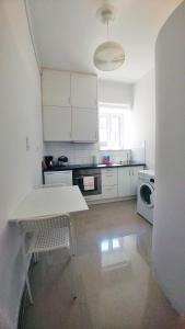 a white kitchen with a table and a microwave at KYMA Apartments - Athens Acropolis 2 in Athens