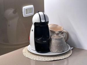 an electric coffee maker and a tea kettle on a plate at Casa Claude in Menaggio