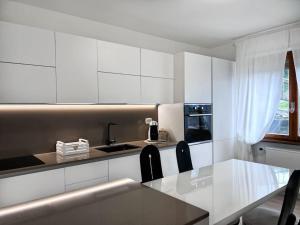 a kitchen with white cabinets and a table with chairs at Casa Claude in Menaggio