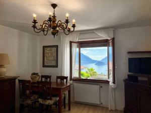 ein Esszimmer mit einem Tisch und einem Fenster in der Unterkunft Casa Claude in Menaggio