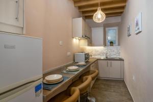 a kitchen with a counter with chairs and a sink at Casa Della Zia in Plaka Milou