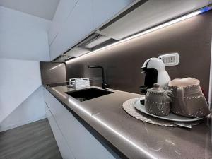 a kitchen with a counter with a sink and a stove at Casa Claude in Menaggio