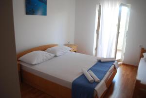 una camera da letto con un letto con due asciugamani sopra di Lokunja Bed&Breakfast a Pag
