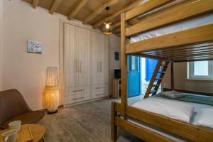 a bedroom with a bunk bed with a chair and a table at Casa Della Zia in Plaka Milou