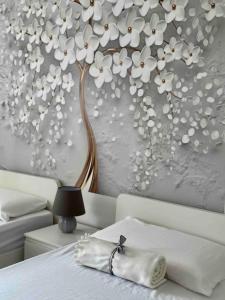 a bedroom with a tree with white flowers on the wall at Casa Claude in Menaggio
