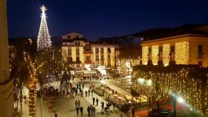 uma árvore de Natal iluminada numa cidade à noite em B&B Maison D'Art em Sorrento