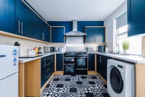 kuchnia z niebieskimi szafkami oraz czarno-białą podłogą w obiekcie Large 7 bedroom town house in Chester City Centre w mieście Chester