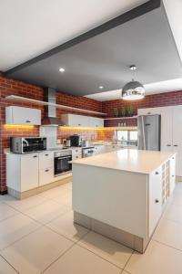uma cozinha com electrodomésticos brancos e uma parede de tijolos em CAG The Vantage Rosebank em Joanesburgo