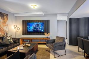 a living room with a couch and a tv at CAG The Vantage Rosebank in Johannesburg