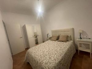 sypialnia z łóżkiem, stołem i lampą w obiekcie El apartamento de Ana -Jerez w mieście Jerez de la Frontera