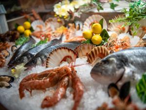 un piatto di alimenti con pesce e gamberetti esposti di Biker Hotel Al Gallo Forcello a Passo Pramollo