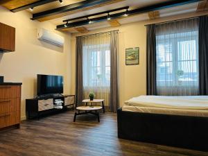 a bedroom with a bed and a flat screen tv at Colonel Suites & Apartments in Riga