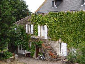 an ivy covered house with a bike parked outside at Kerderff, longere entre plage et foret, TK30 in Carnac