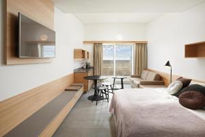 VegamótにあるEiðhús Apartmentsのベッドとリビングルームが備わるホテルルームです。