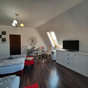 ein Schlafzimmer mit einem Bett und einem Tisch mit einem TV in der Unterkunft Pannónia Rooms and Apartments in Satu Mare