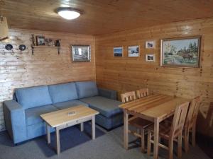 Jakubovany的住宿－Drevenica u Porubäna，客厅配有蓝色的沙发和桌子