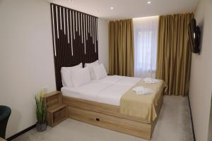 ein Schlafzimmer mit einem großen Bett mit weißer Bettwäsche in der Unterkunft Sax-Win in Požega