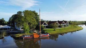 a couple of boats are sitting in the water at Vakantiehuis aan het water met hottub in Dokkum