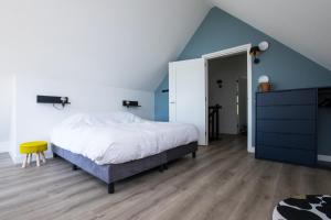 a bedroom with a bed and a blue ceiling at Vakantiehuis aan het water met hottub in Dokkum