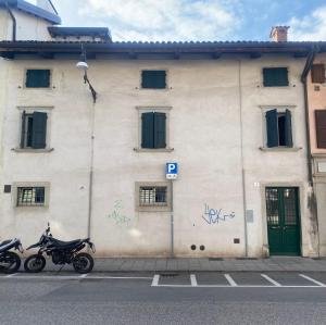 zwei Motorräder, die vor einem Gebäude mit Graffiti geparkt werden in der Unterkunft Appartamento Palazzo Montegnacco-Braida in Udine
