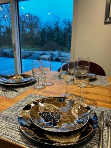 einen Tisch mit einem Teller und Weingläsern darauf in der Unterkunft Gite des Pommiers in Sotteville