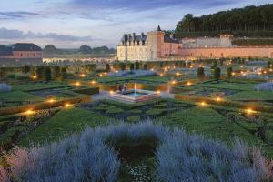 einen Garten vor einem Schloss in der Nacht in der Unterkunft La Bienheureuse Maison, vue sur le Château de Villandry in Villandry