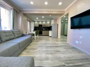 a living room with a couch and a flat screen tv at Family Haven Apartment in Chişinău