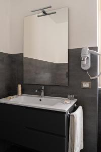 baño con lavabo y espejo grande en Damatti Room en Messina