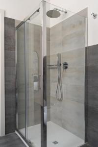 a shower with a glass door in a bathroom at Damatti Room in Messina