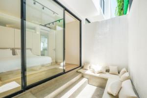 a room with a bed and a glass wall at Oasis Smart Villa 3 Canggu in Canggu