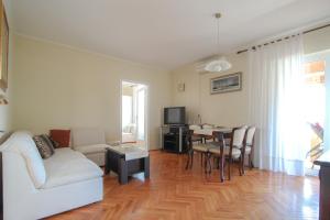een woonkamer met een witte bank en een tafel bij Martinis A4 in Novigrad Istria