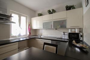 een keuken met witte kasten en een zwart aanrecht bij Martinis A4 in Novigrad Istria