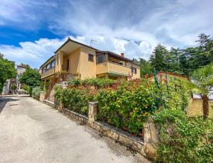 een huis met een hek naast een straat bij Martinis A4 in Novigrad Istria