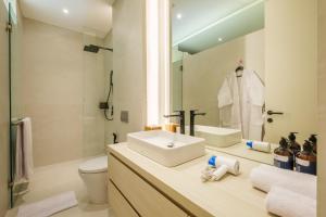 La salle de bains est pourvue d'un lavabo, de toilettes et d'un miroir. dans l'établissement Oasis Smart Villa 3 Canggu, à Canggu