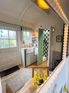 a kitchen with a sink and a table with flowers at Shepherd's Hut at The Granary in Steyning