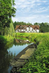 uma casa no meio de um rio com uma casa em Hotel am Spreebogen em Burg