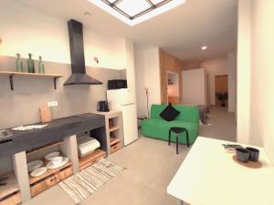 a living room with a green couch and a kitchen at Acogedor loft central en Valencia_ calamochaA in Valencia