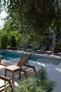 a swimming pool with chairs and a table next to it at MAISON - ELEA in Ierissos