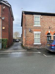 a car parked in front of a brick building at 48 South St in Alderley Edge