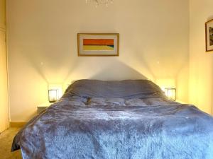 a bedroom with a bed with two lamps and a picture at 48 South St in Alderley Edge