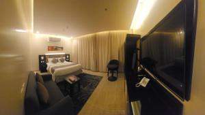 a bedroom with a bed and a flat screen tv at رفان للشقق المخدومة in Khamis Mushayt
